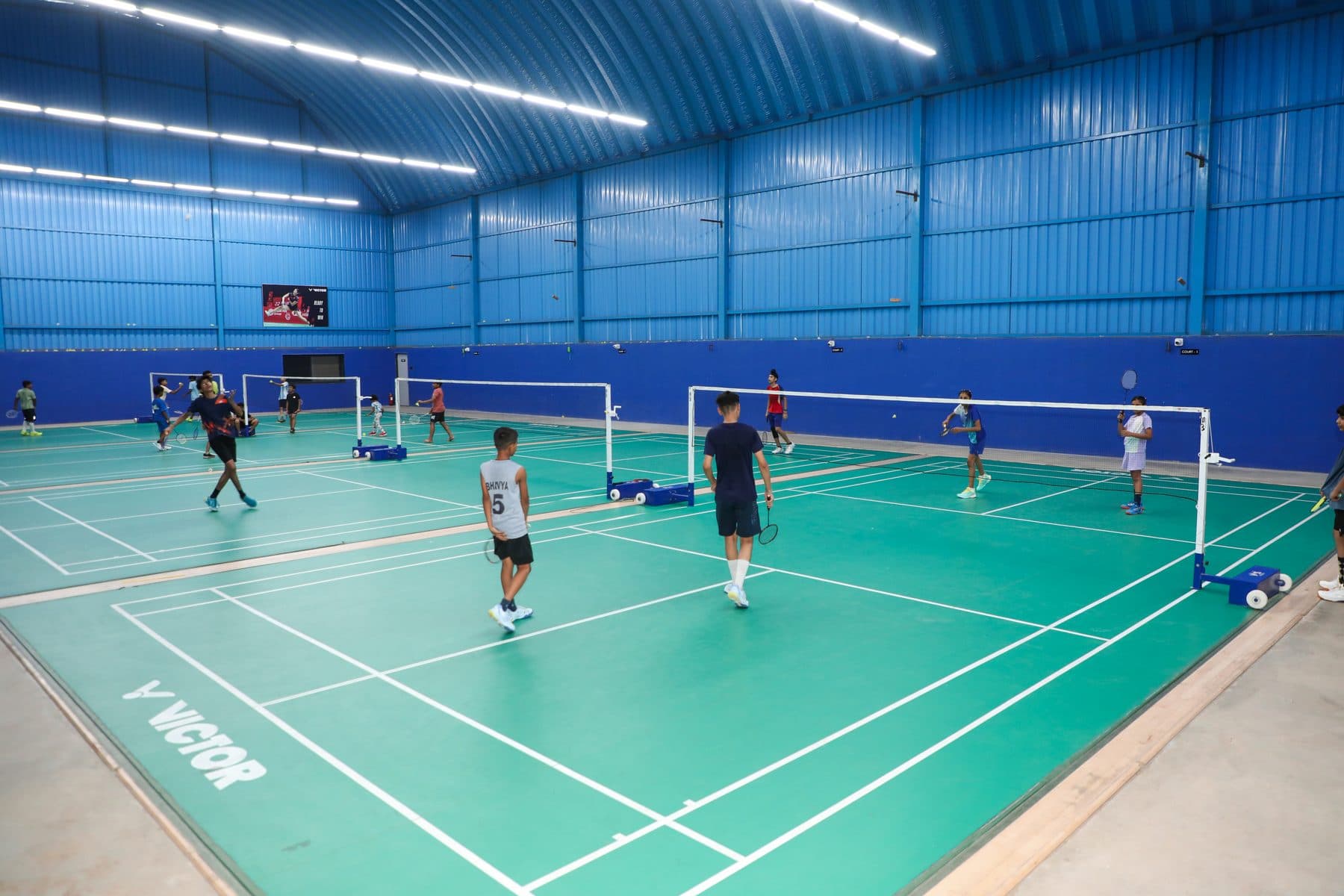 Indoor badminton courts at Axon Badminton Academy Palanpur — Canadian Maple Wood VICTOR flooring